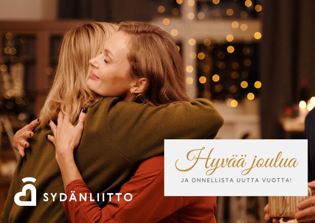 Kaksi henkilöä halaamassa toisiaan jouluisessa tunnelmassa.